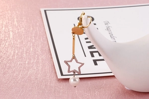 Détail de boucles d'oreilles étoile en acier inoxydable avec pendentif en perle