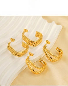 Detail view of gold titanium steel irregular layered and twisted hoop earrings