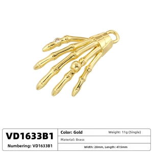 Detailed view of a gold brass skeleton hand pendant with gemstone and size specs
