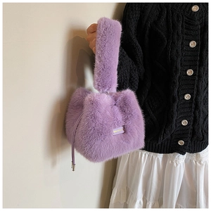 Close-up of a purple plush bucket bag featuring a Love Every Day woven label detail