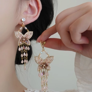 Boucles d'oreilles papillon dorées avec cristaux roses et longs glands élégants