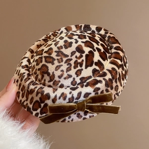 Detailed view of leopard print hair clip with brown velvet bow and soft fabric texture