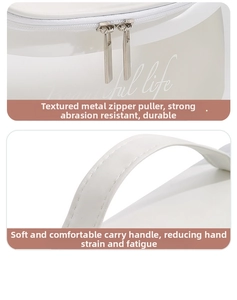 Detail of silver dual metal zippers and precision stitching on a white leather toiletry bag