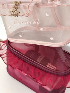 Close-up of mesh makeup bags with ruffle lace trim and golden star zipper charms