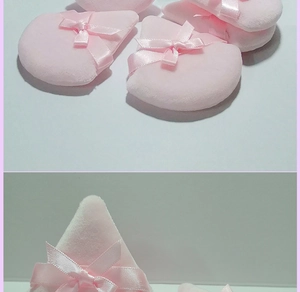Detail of pink crystal velvet makeup puffs with ribbon bows for loose powder application