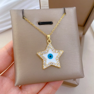 Detailed shot of gold star pendant featuring a blue evil eye and sparkling zircons