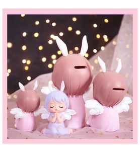 Macro detail of cute pink resin angel girl figurines and rabbit-eared money bank