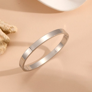 Detailed shot of silver minimalist open bangle with hinge closure on a stone prop