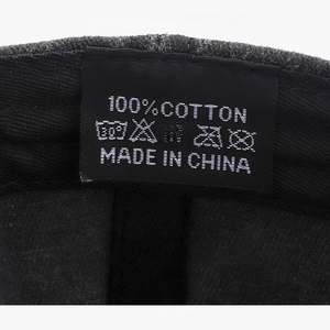 Close-up of internal wash label showing 100% cotton fabric and care symbols on baseball cap