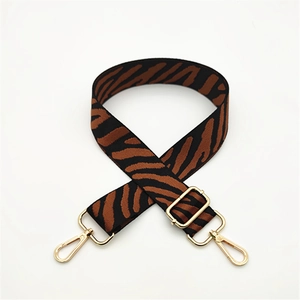 Crossed zebra print bag strap in brown and black with adjustable golden metal hooks