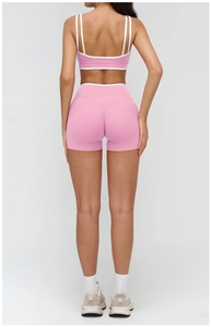 Rear view of pink yoga set with contrast piping on sports bra and high-waist shorts