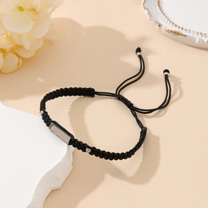 Minimalist black braided bracelet with silver rectangular metal plate on white stone