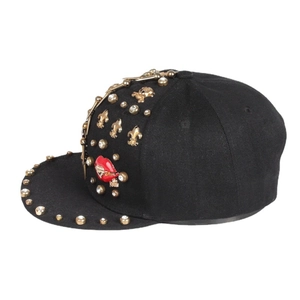 Hip-hop snapback hat in black cotton with gold rivets, cross charms, and lip kiss accessory