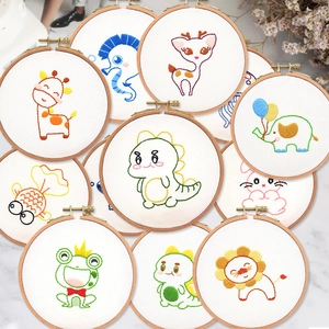 Flat lay of multiple animal embroidery DIY kits with wooden hoops on marble background