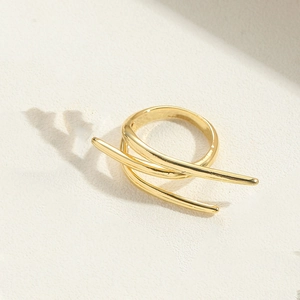 Macro shot of 14K gold plated double-layer wrap ring on textured beige surface