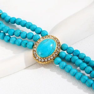 Détail du bracelet en perles de turquoise à trois rangs avec gemme ovale et strass