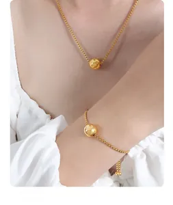 Detailed view of a gold plated box chain necklace with a minimalist polished metal bead