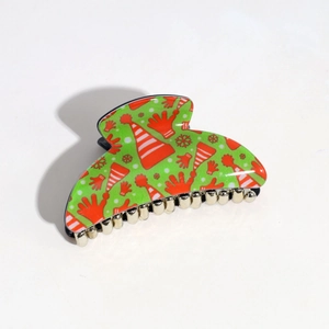 Detail of green semi-circle hair claw clip with festive Santa and snowflake print