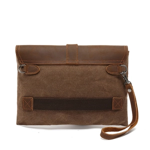 Retro dark brown canvas clutch bag with leather trim and metal clasp on white background