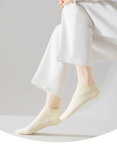 Detail of light yellow ribbed knit cotton ankle socks showing soft fabric texture