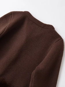 Detaillierte Makroansicht der dunkelbraunen Stricktextur am hinteren Kragenbereich