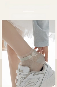 Close-up of high-elasticity lace cuff on thin summer socks with sweet bow detail