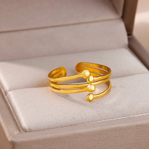 Detailed macro of golden multi-layer adjustable ring with round beads on velvet cushion