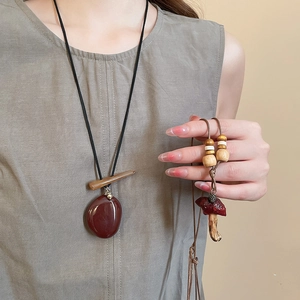 Detail of vintage mushroom pendant necklace with wooden beads and resin stone charm