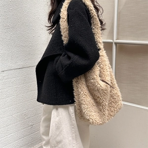 Detail of the soft faux shearling texture and long strap of this large tote bag