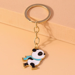 Close-up of cute cartoon panda skating keychain with gold ring and enamel finish