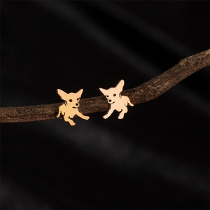 Boucles d'oreilles Chihuahua en or rose sur une branche sur fond noir minimaliste