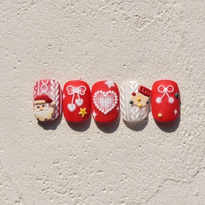Détail de stickers à ongles de Noël avec relief du Père Noël 3D et motifs de maille blanche