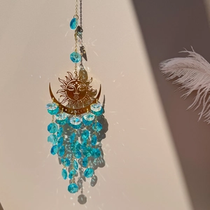 Detailed view of sun and moon crystal suncatcher with blue faceted beads and gold metal