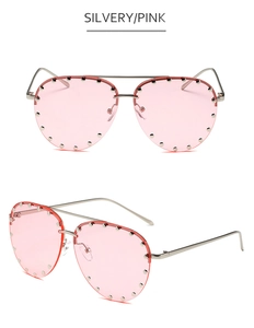 Close-up of pink pilot sunglasses with silver metal frame and rivet detail