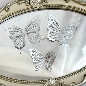 Detailed view of three silver hollow butterfly cake toppers placed on a vintage gold frame