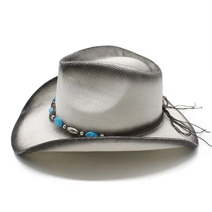 Detail of white straw cowboy hat with turquoise beads and silver floral metal accents