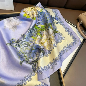 Elegant purple silk scarf with floral patterns displayed on a tray for fashion styling