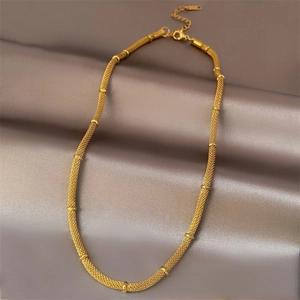 Elegant gold woven mesh necklace with bead accents on premium dark silk background