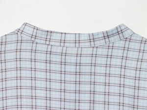 Detail of blue plaid fabric texture and neckline stitching on short fitted dress