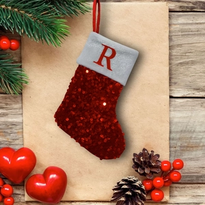 Close-up of red sequined Christmas stocking with white fur and red letter R embroidery