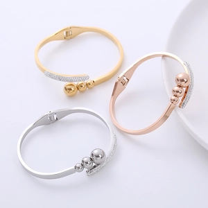 Vista dettagliata dei bracciali a molla lucidi in oro, oro rosa e argento con pavé