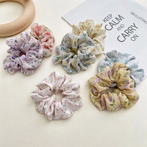 Detail of floral chiffon scrunchies in pastel pink, purple and blue soft fabric textures