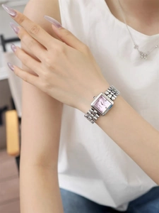 Silver square watch with pink dial and metal strap worn on wrist for casual style