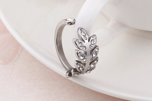 Vue macro d'une bague feuille en argent avec zircons sur un support céramique