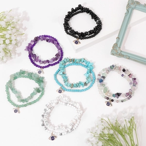 Detail view of colorful beaded stone bracelets with evil eye charms on elegant flat lay