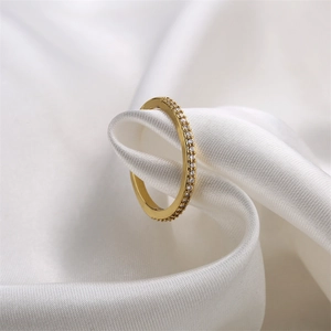 Close-up of gold ring with micro-set zircons on white silk background with milgrain detail