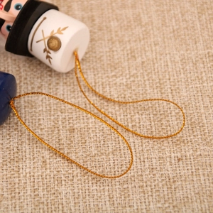Close-up of wooden nutcracker ornament with golden hanging cord and wheat pattern details