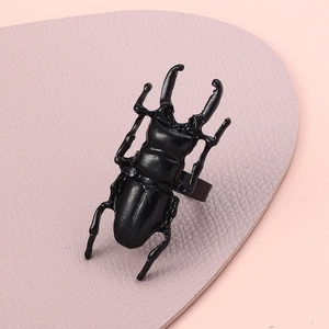 Unique black beetle ring with detailed insect anatomy on soft purple leather base
