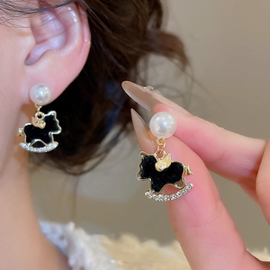 Close-up of vintage black rocking horse earrings with pearls and crystals