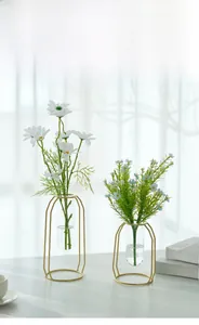 Detail of creative gold metal frame test tube vases with white and blue daisies